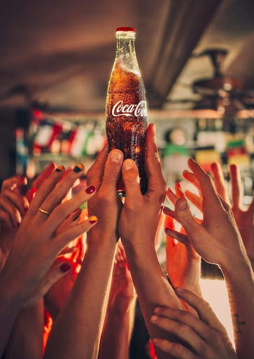 Group of people sharing CocaCola bottles